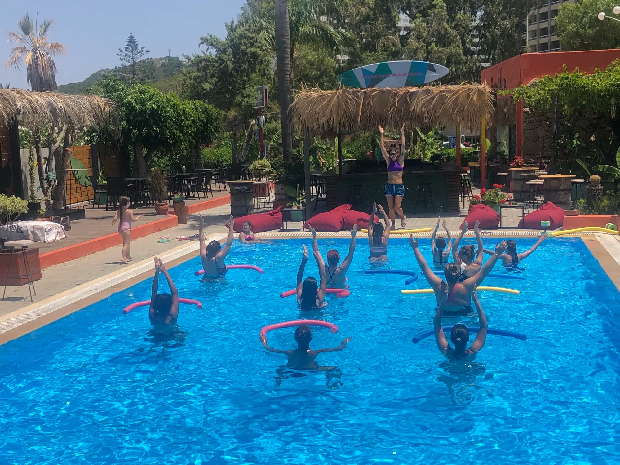 Μάθημα aqua aerobics με τους συμμετέχοντες να σηκώνουν πλωτήρες ψηλά